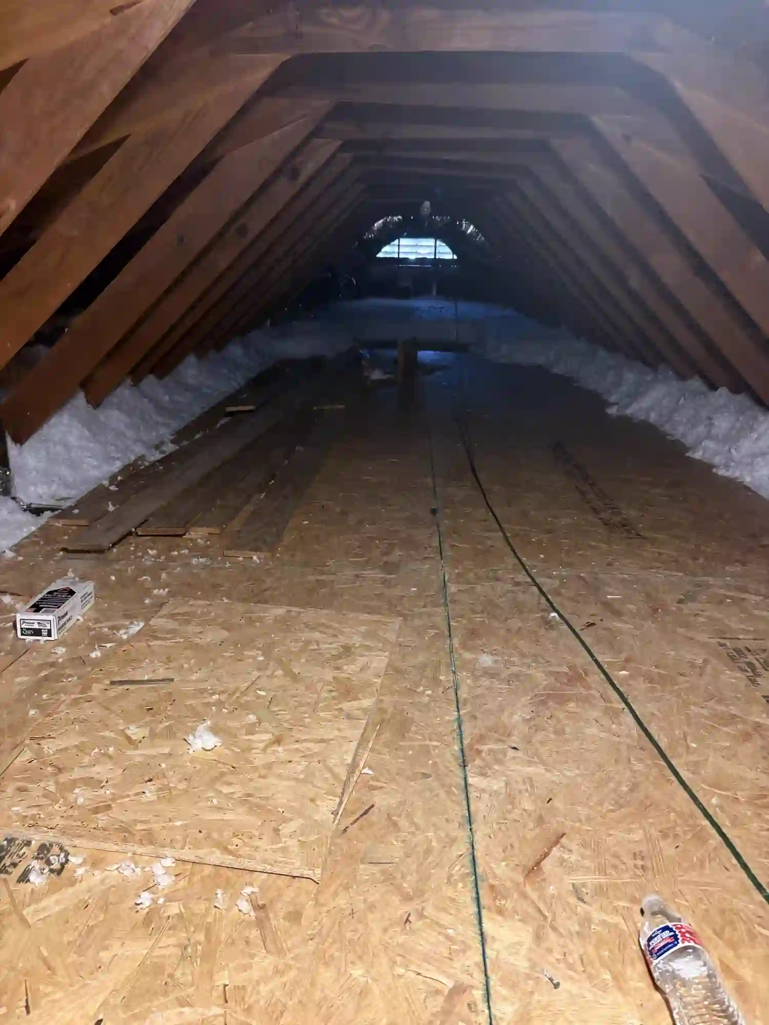 Attic space with new OSB subfloor over the trusses, ready for finishing